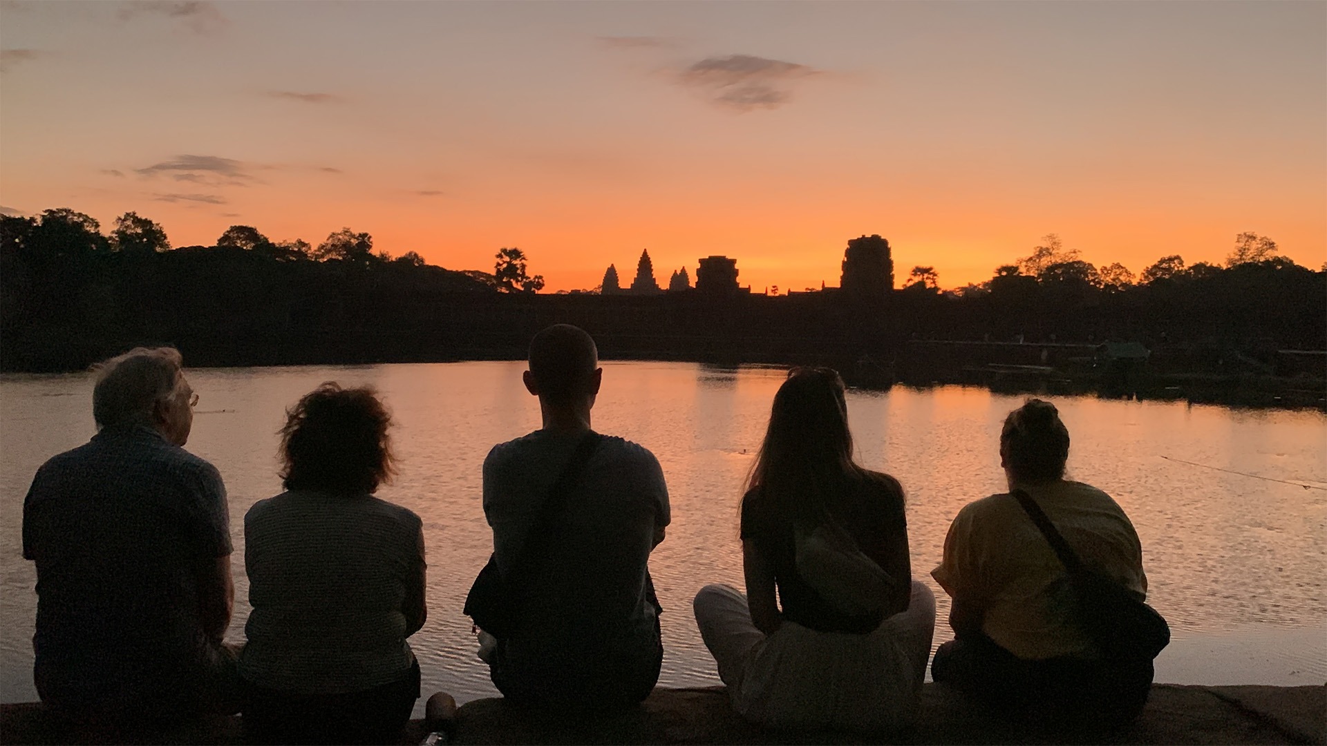 Angkor Sunrise tour sitting on the bank of outer moat of Angkor Wat